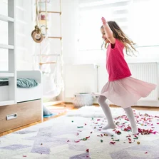 Illustration - Ihr Experte für schönes Wohnen - Ein junges Mädchen tanzt im Kinderzimmer auf ihrem Teppich.